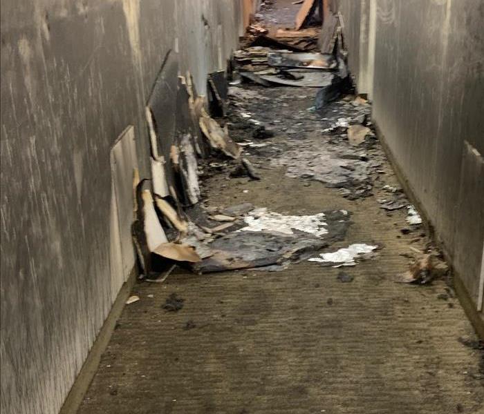 Fire damaged hallway destroyed walls, ceiling and carpets